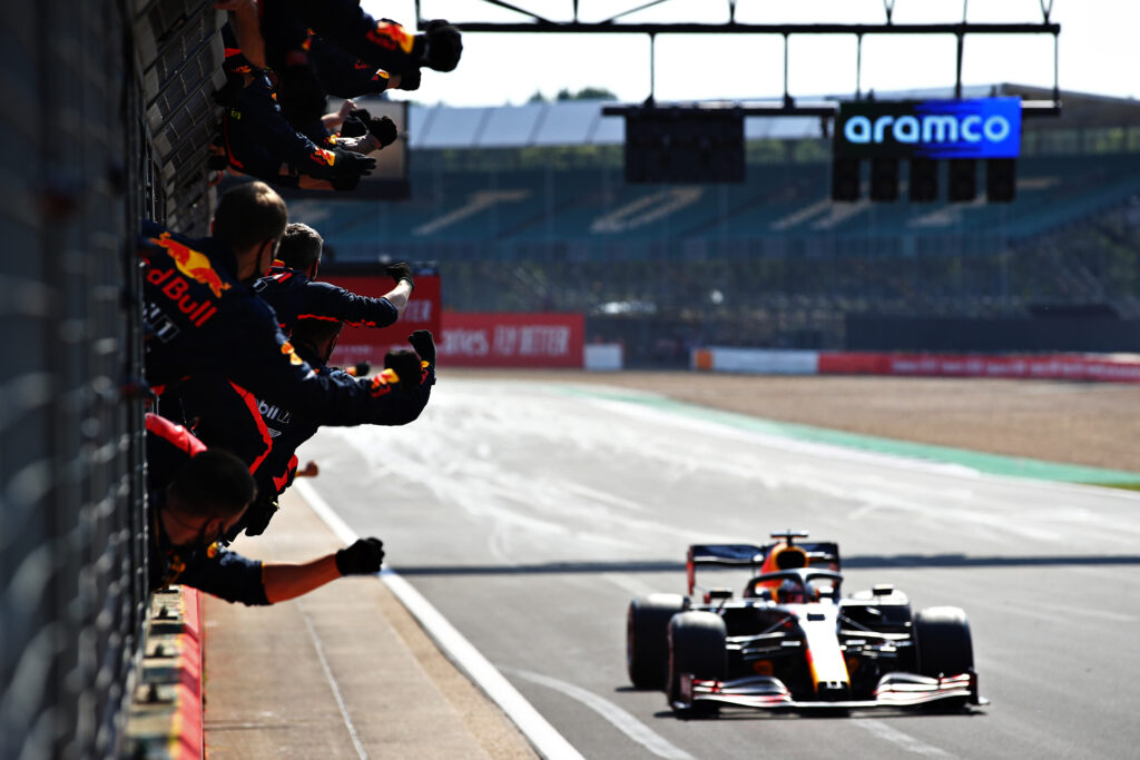 NORTHAMPTON, ENGLAND - AUGUST 09: The Red Bull Racing team celebrate on the pitwall as race winner Max Verstappen of Netherlands and Red Bull Racing crosses the finish line during the F1 70th Anniversary Grand Prix at Silverstone on August 09, 2020 in Northampton, England. (Photo by Mark Thompson/Getty Images)