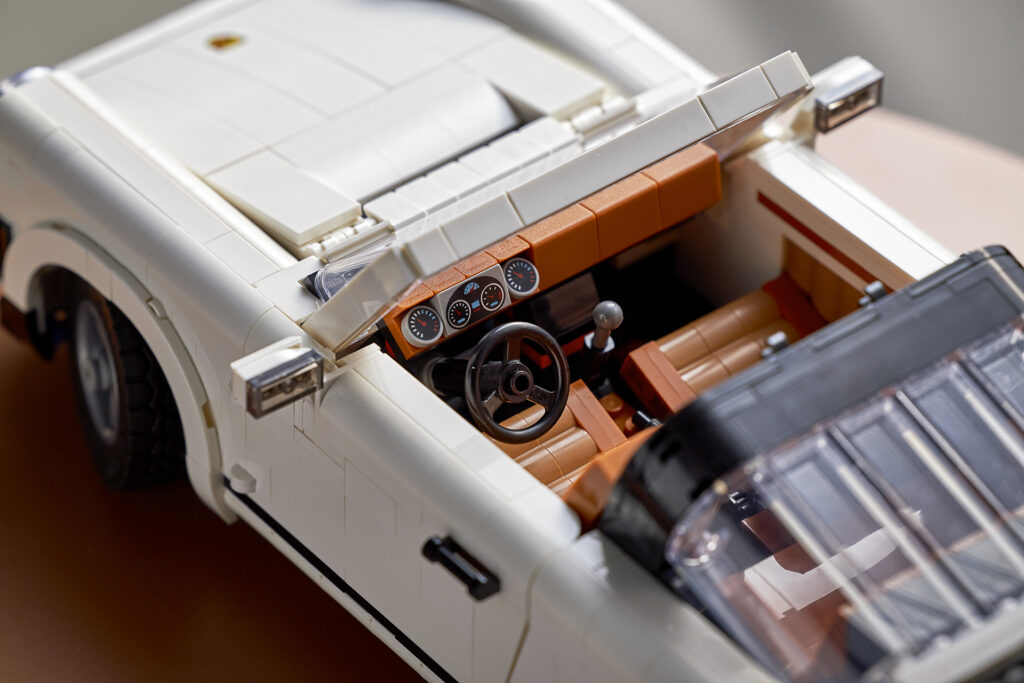 A close up shot of the interior of the new LEGO Porsche set 10295 featuring gear shifter, handbrake, and working steering wheel