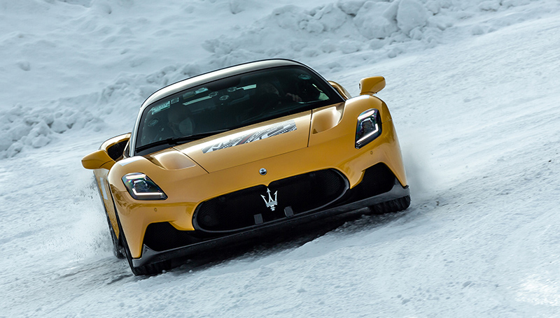 Yellow Maserati MC20 cold weather testing on a snowy track in Italy