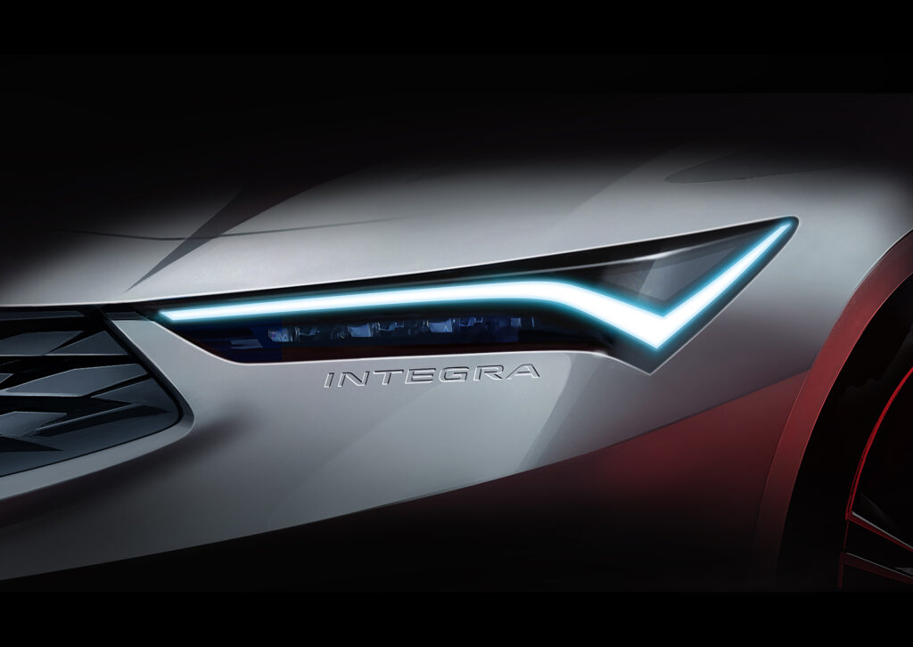 A Teaser Image of the 2022 Acura Integra showing just the headlight with the "Integra" logo embossed in the bumper just below.