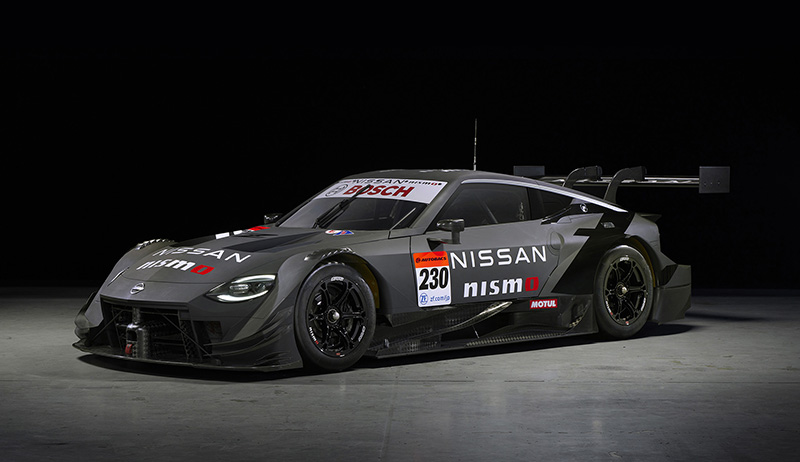 Nissan Z GT500 race car photographed in a dark studio with a spotlight over it.