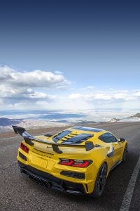 Rear 3/4 view of a Chevrolet Corvette ZR1 Coupe with ZTK Performance Package, highlighting the split-window rear hatch, driving down a mountain road. Preproduction model shown. Actual production model may vary.