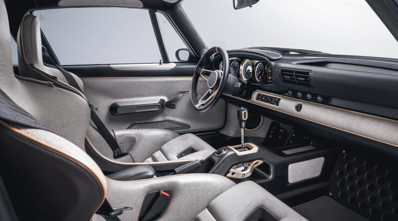 Interior view. Power is delivered to the rear wheels via a bespoke six-speed manual transmission with raised shift lever and exposed gear linkage. The lower interior environment is finished in satin carbon fiber, and the driver can select from 5 Bosch-developed traction control modes via the selector knob along the center console.